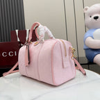 Gucci pale pink bag with G monogram pattern, side view, top handle and gold zip