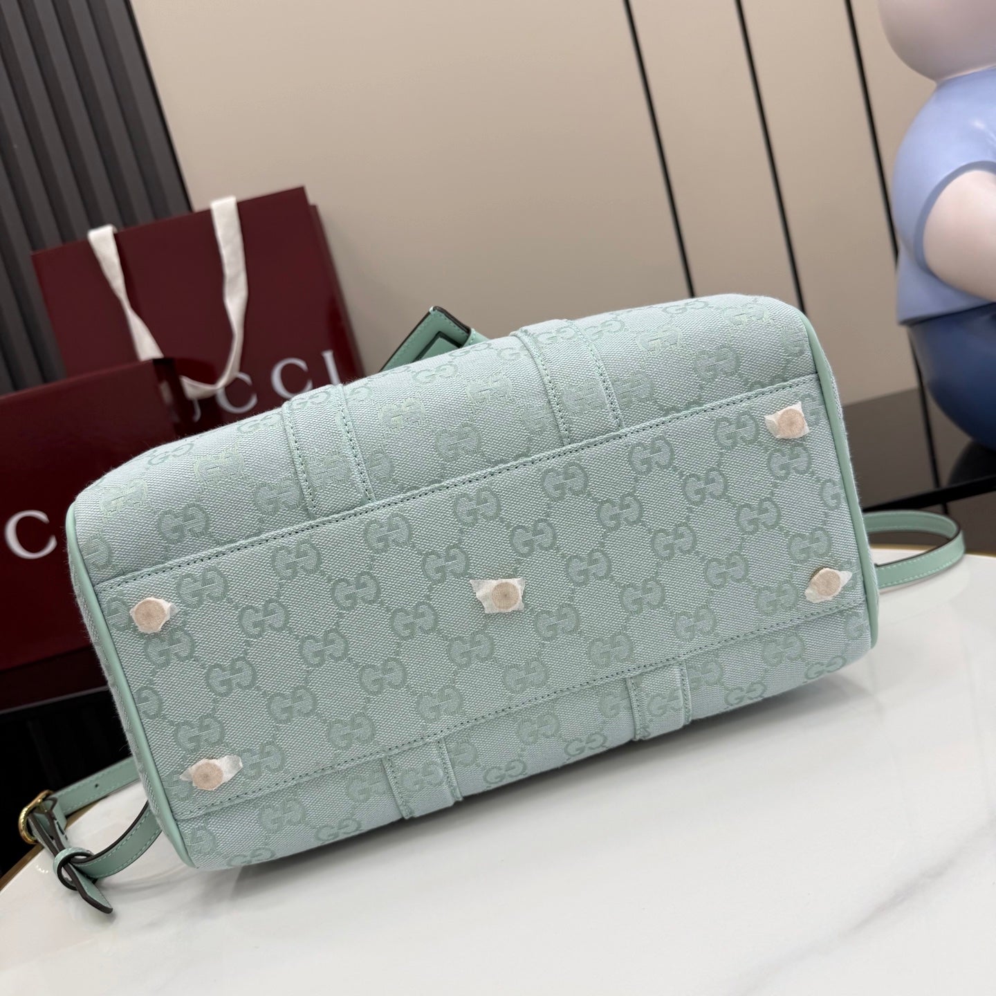 Mint GG-pattern barrel bag with front stud accents and crossbody strap.