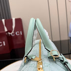 Mint handbag top handle detail with gold-tone hardware and GG-pattern body.