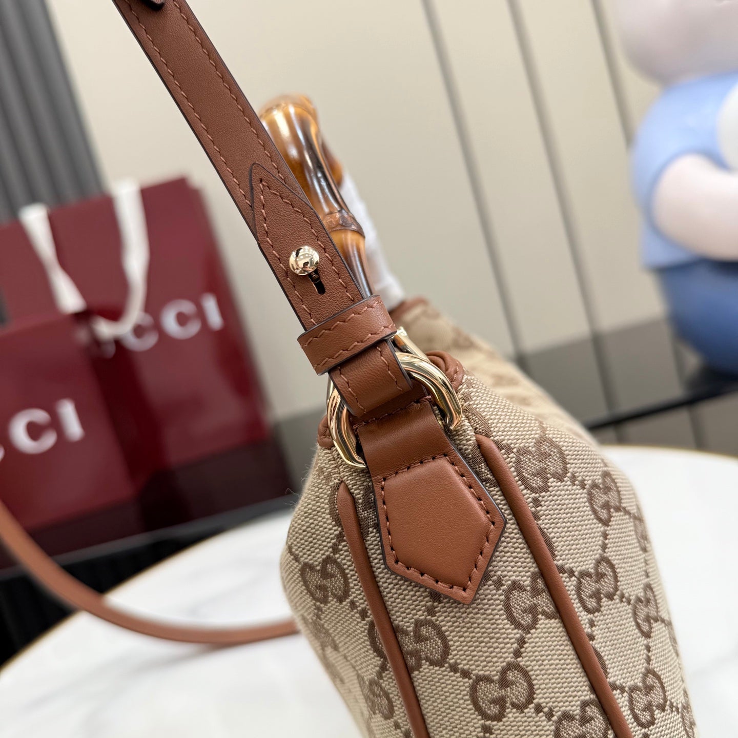 Gucci bag strap and buckle detail with brown leather and GG canvas body