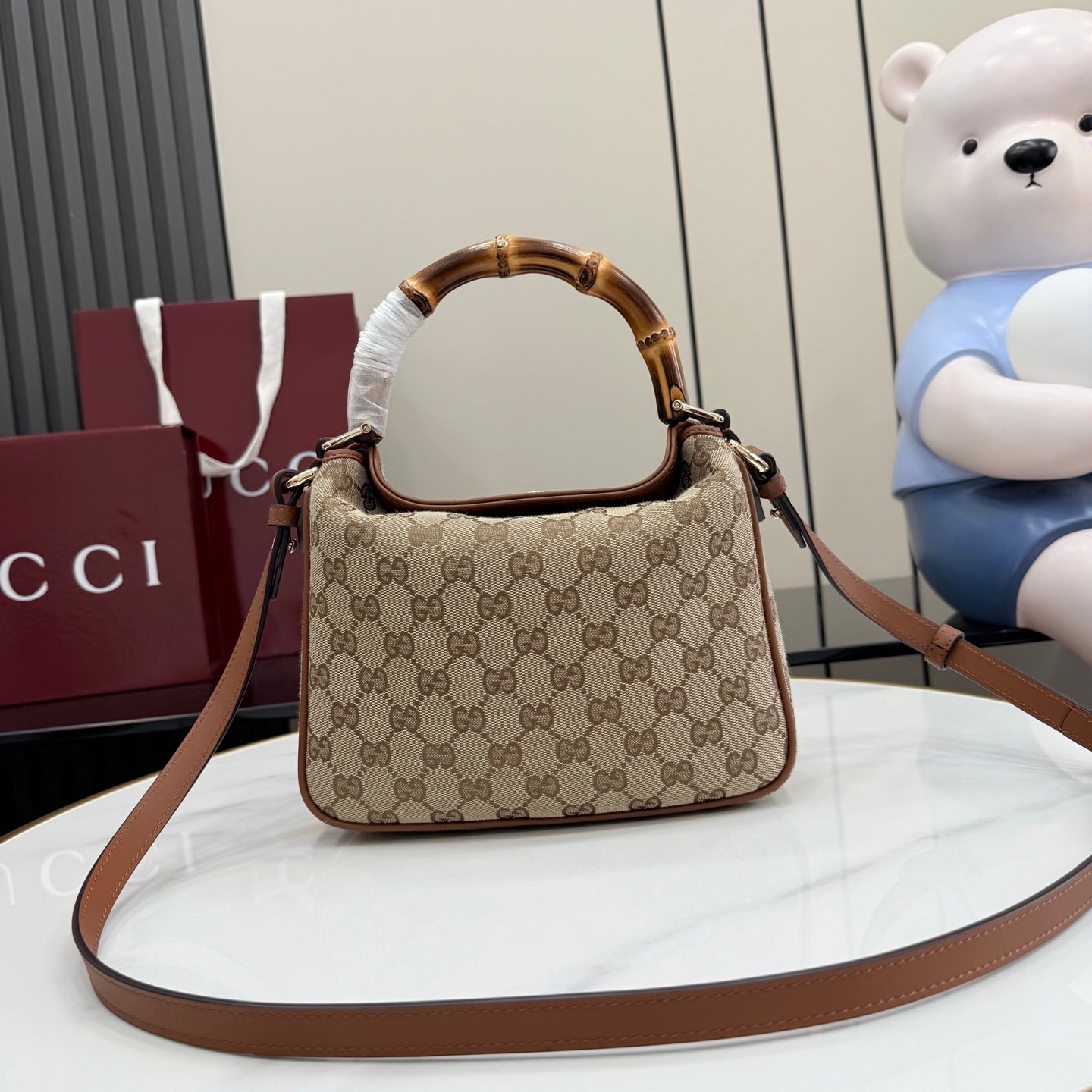 Gucci hobo bag with brown leather shoulder strap and tan GG monogram pattern