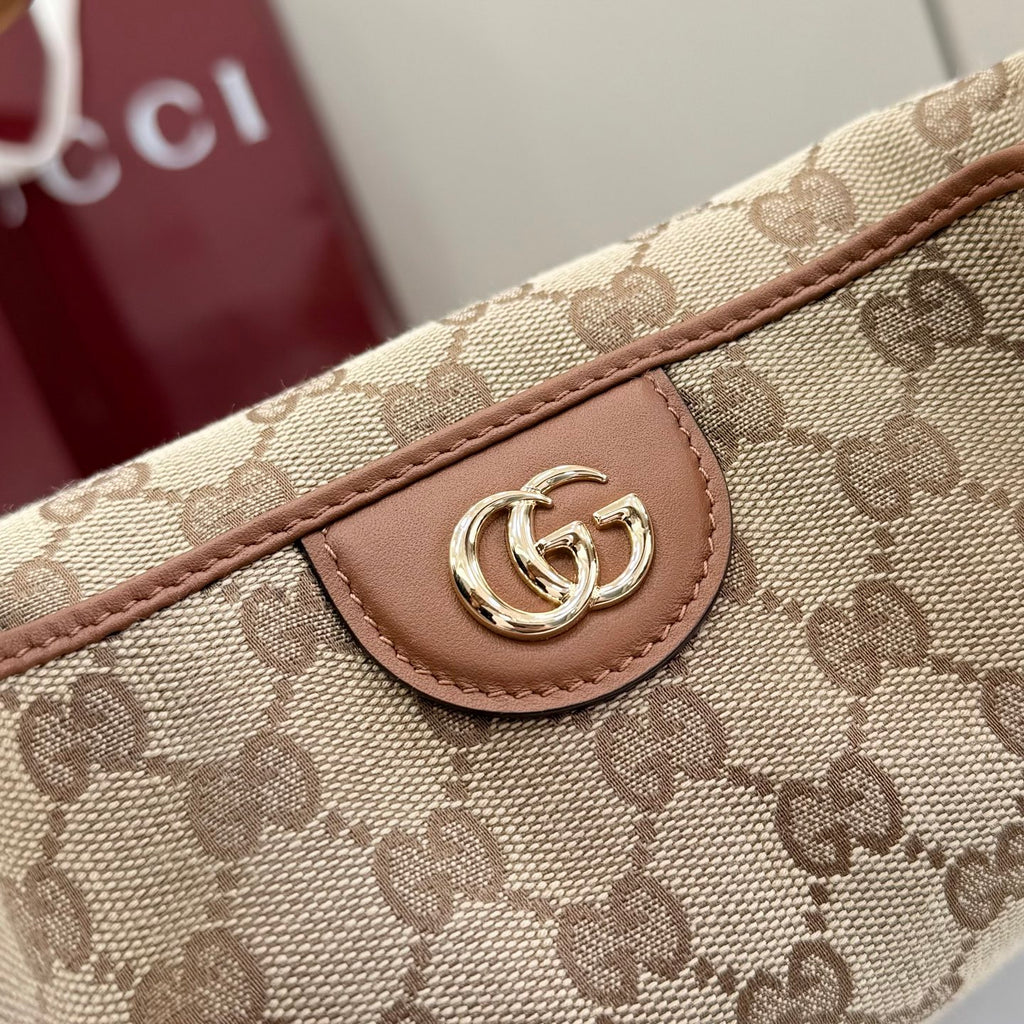 Gucci canvas bag close-up of GG print, leather strap, and silver logo clasp