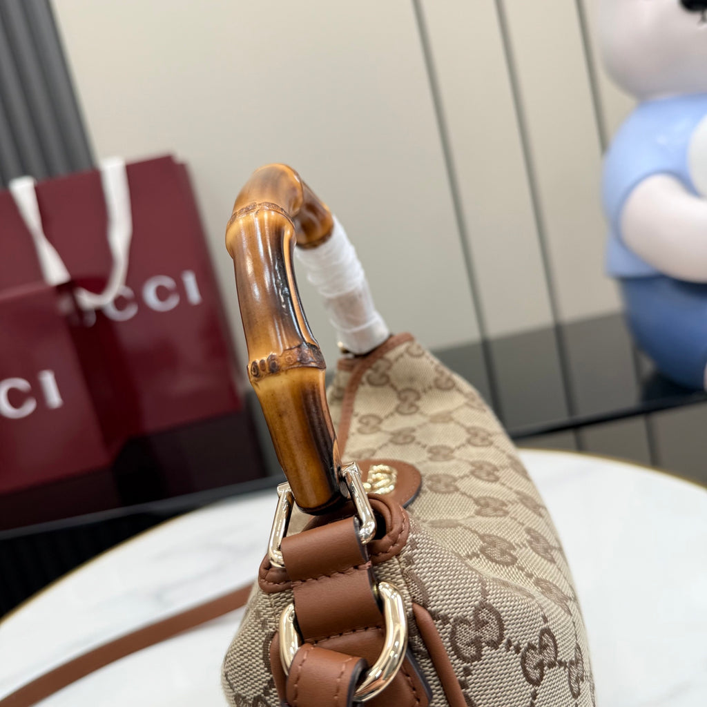 Gucci hobo bag close-up of bamboo handle and metal hardware on GG canvas