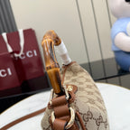 Gucci hobo bag close-up of bamboo handle and metal hardware on GG canvas