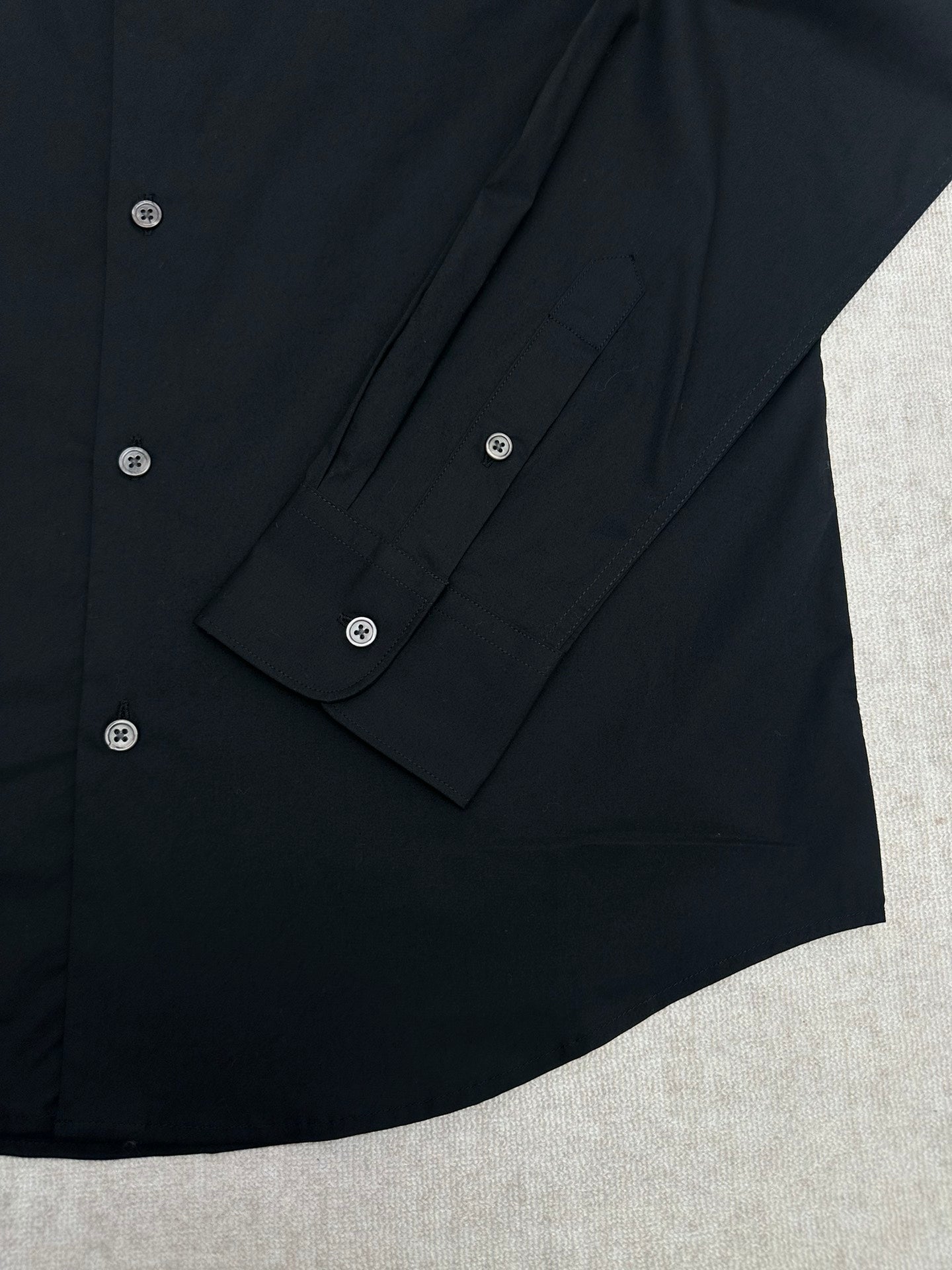 Black long-sleeve shirt sleeve cuff with button and stitched button placket