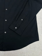 Long-sleeve button-up shirt sleeve cuff with dark buttons and stitching