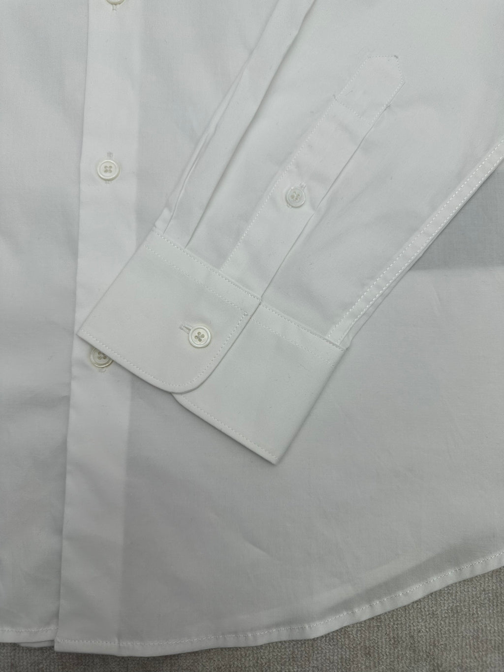 White shirt sleeve cuff and double-button placket detail