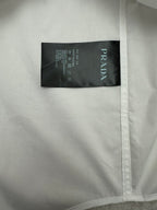 Prada long-sleeve button-up shirt inner label, white fabric with black tag