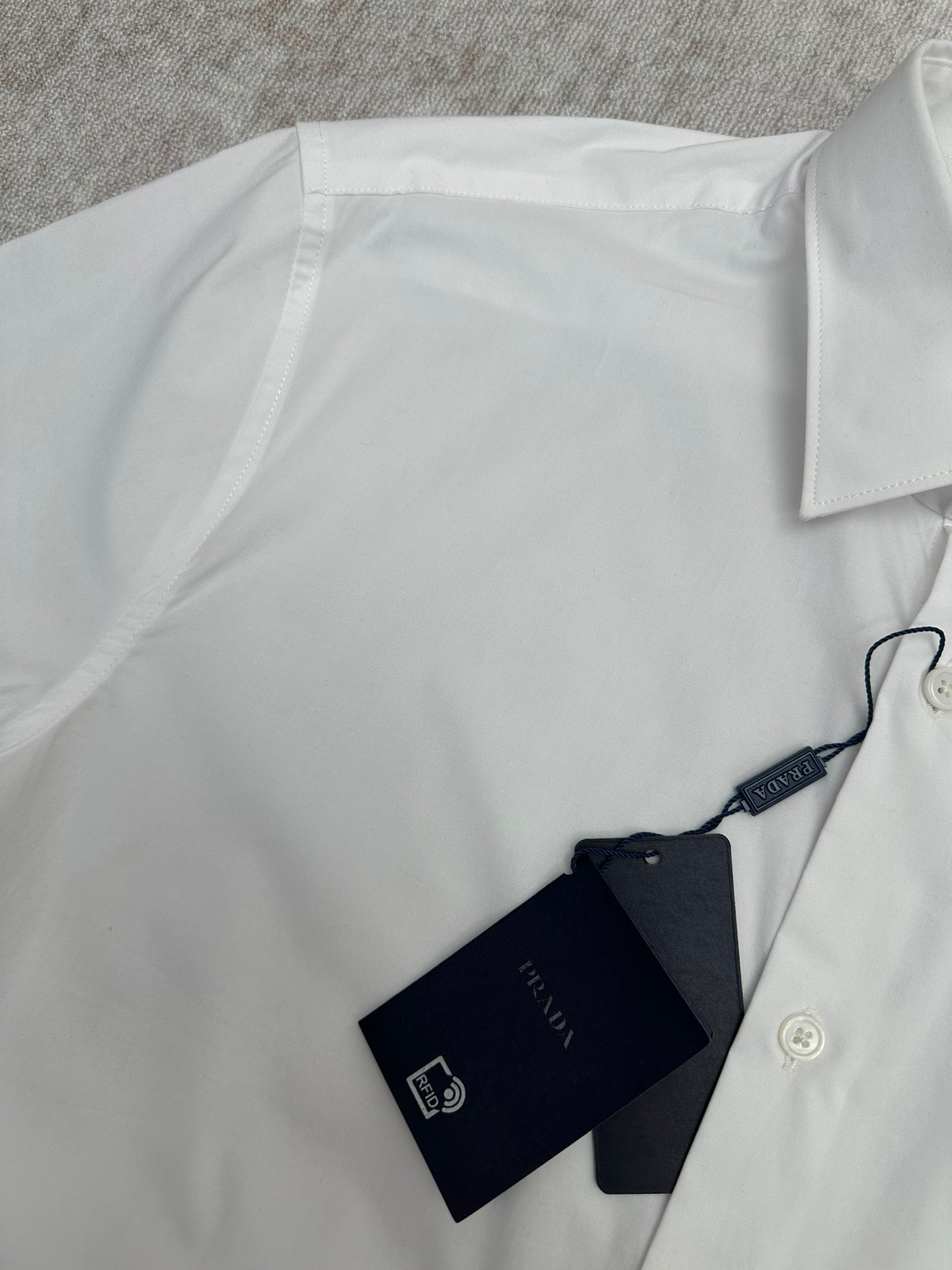 Prada long-sleeve button-up shirt with hang tags, white, close-up neckline