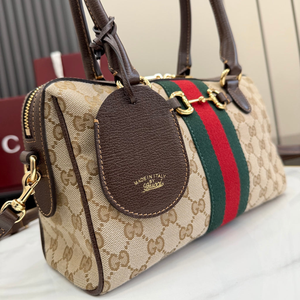 Striped GG canvas handbag with brown leather oval patch, zip closure and dual straps