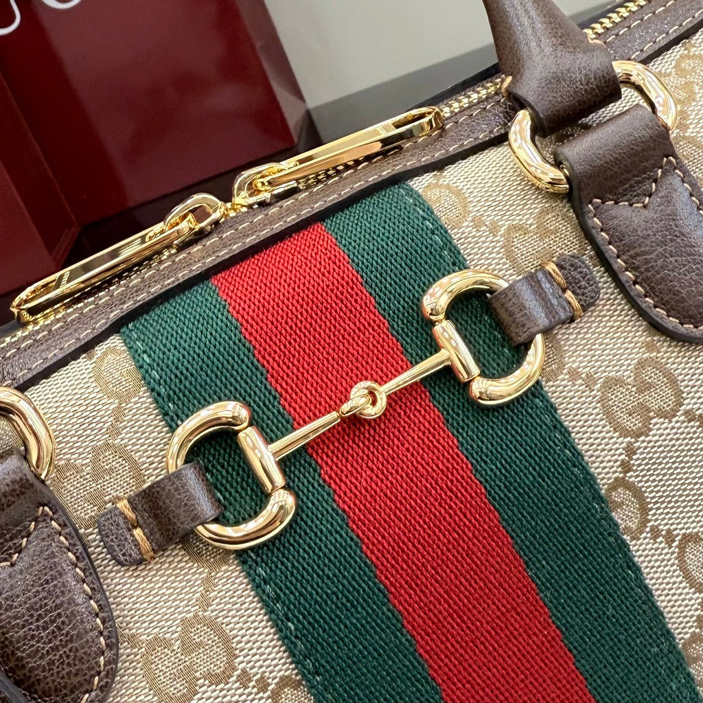 Gucci handbag close-up: green-red web stripe with gold chain links and brown leather edging