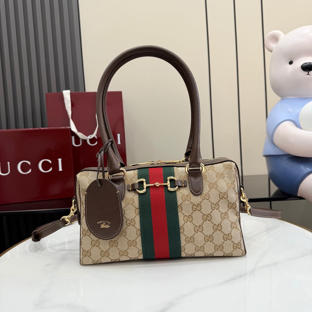 Gucci canvas handbag with brown leather handles, gold hardware, and green-red stripe panel