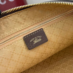 Gucci handbag interior close-up showing brown leather brand patch on tan lining
