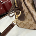 Striped canvas mini handbag close-up with brown leather strap and gold clasp hardware