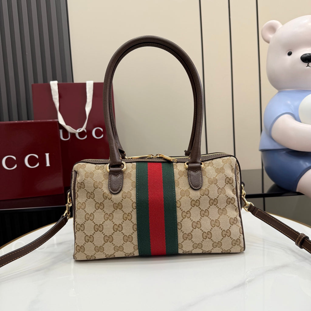 Gucci canvas handbag with brown top handles, gold clasp, and green-red stripe