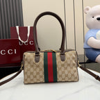 Gucci canvas handbag with brown top handles, gold clasp, and green-red stripe
