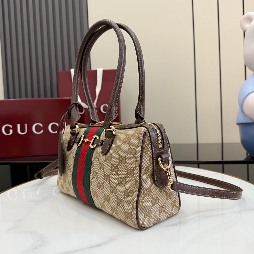 Gucci canvas handbag with brown leather handles, green-red stripe, and crossbody strap