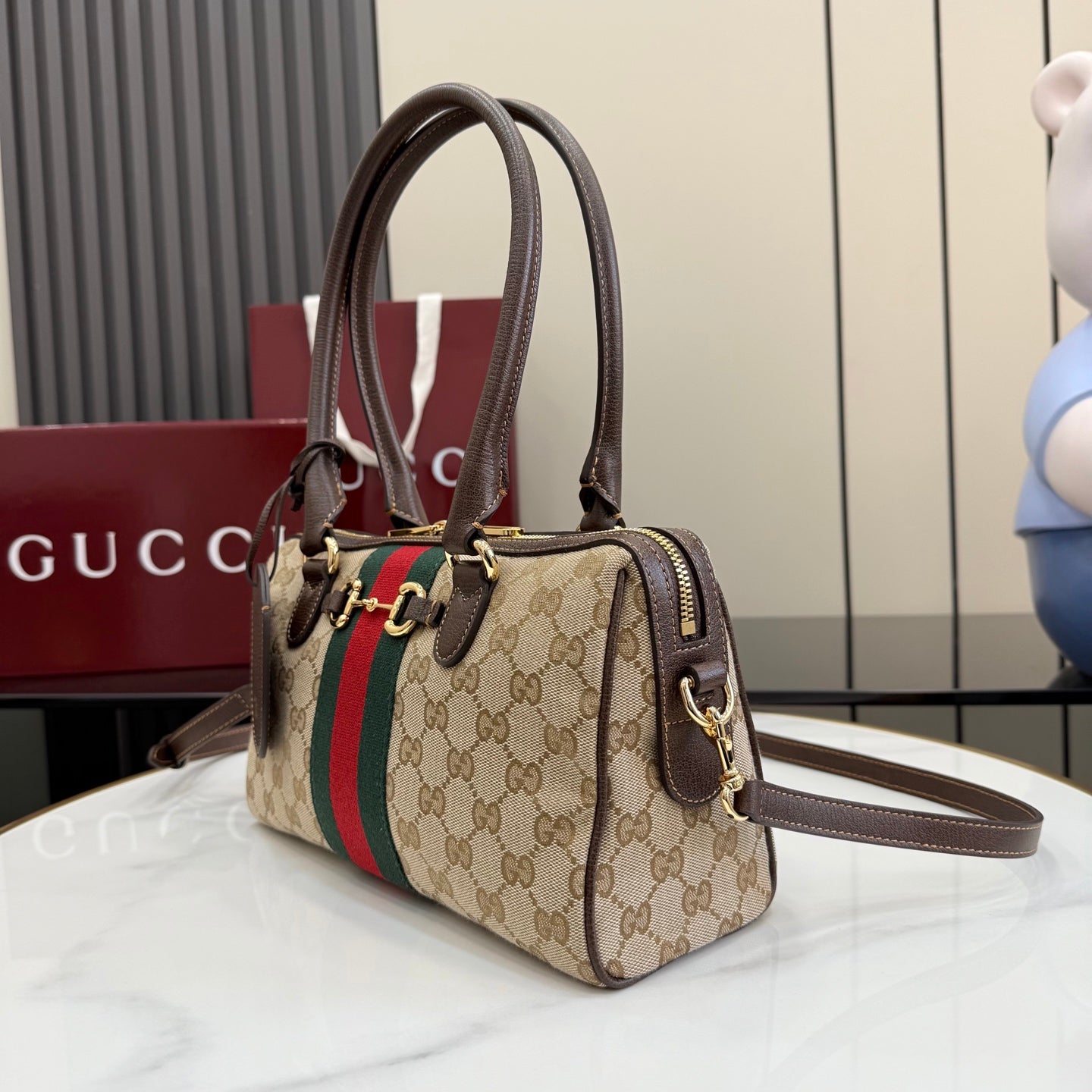 Gucci canvas handbag with brown leather handles, green-red stripe, and crossbody strap