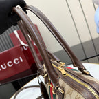 Gucci handbag close-up of brown top handles with gold hardware and zipper edge