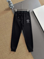 Black jogger pants with drawstring waistband and Versace patch logo