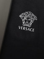 Black sweatshirt chest close-up with Versace Medusa and wordmark