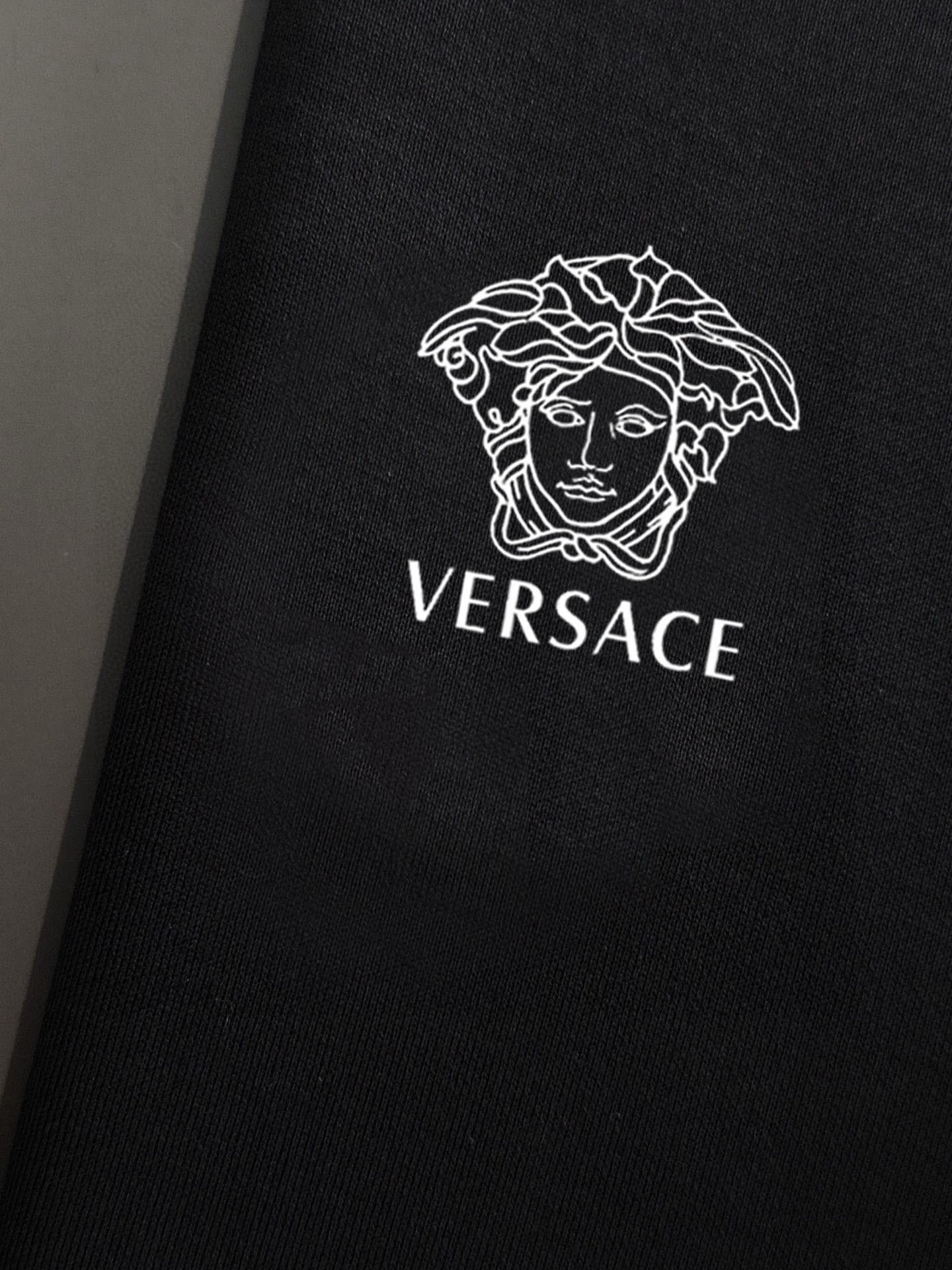Black sweatshirt chest close-up with Versace Medusa and wordmark