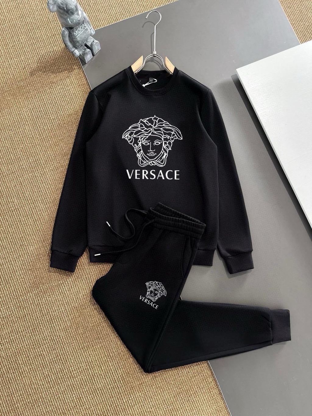 Black sweatshirt and jogger set with Versace Medusa logo, on hangers