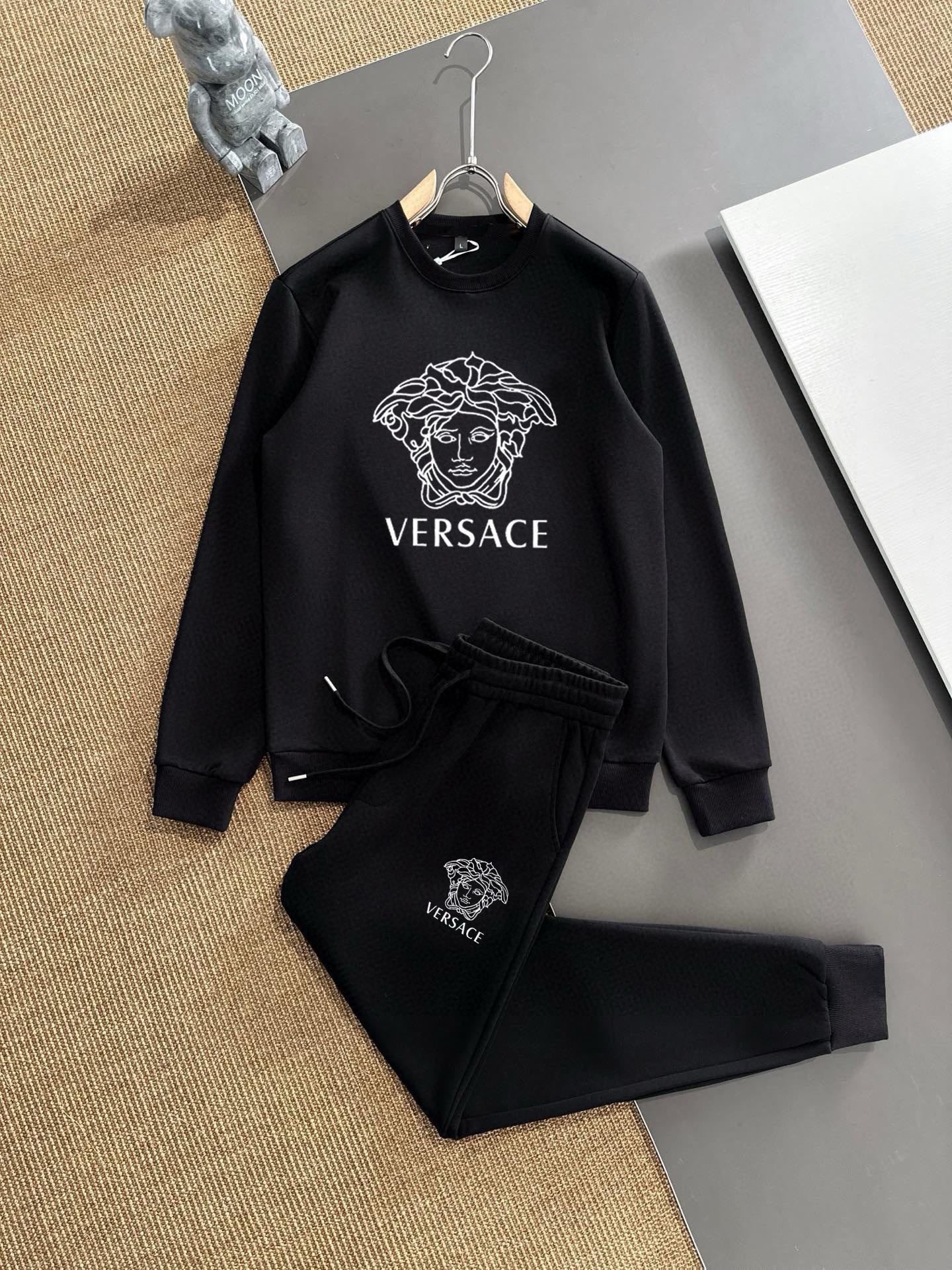 Black sweatshirt and jogger set with Versace Medusa logo, on hangers