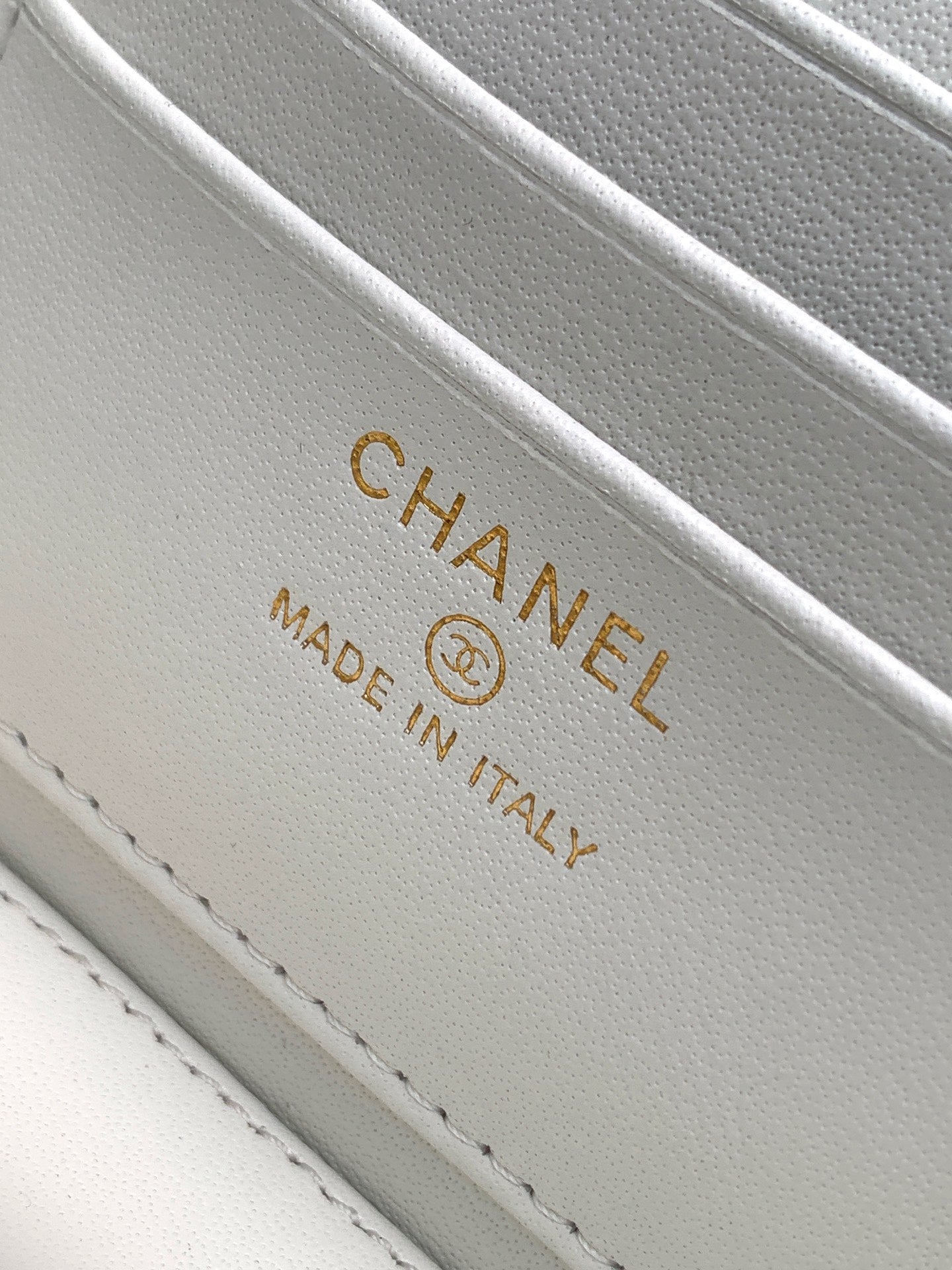 White leather label reading CHANEL and MADE IN ITALY on stitched trim