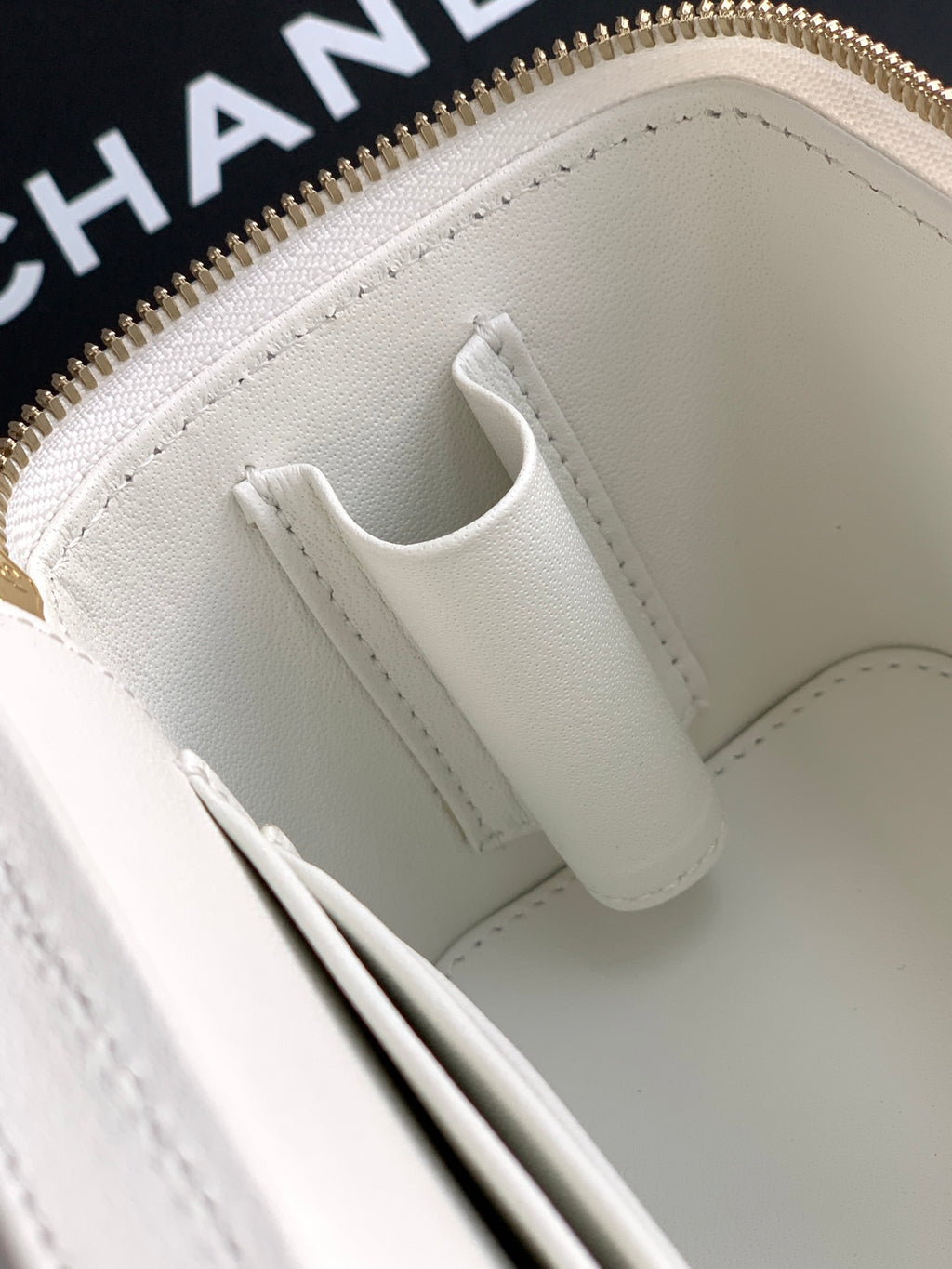 White leather bag interior with stitched top edge and slip pocket