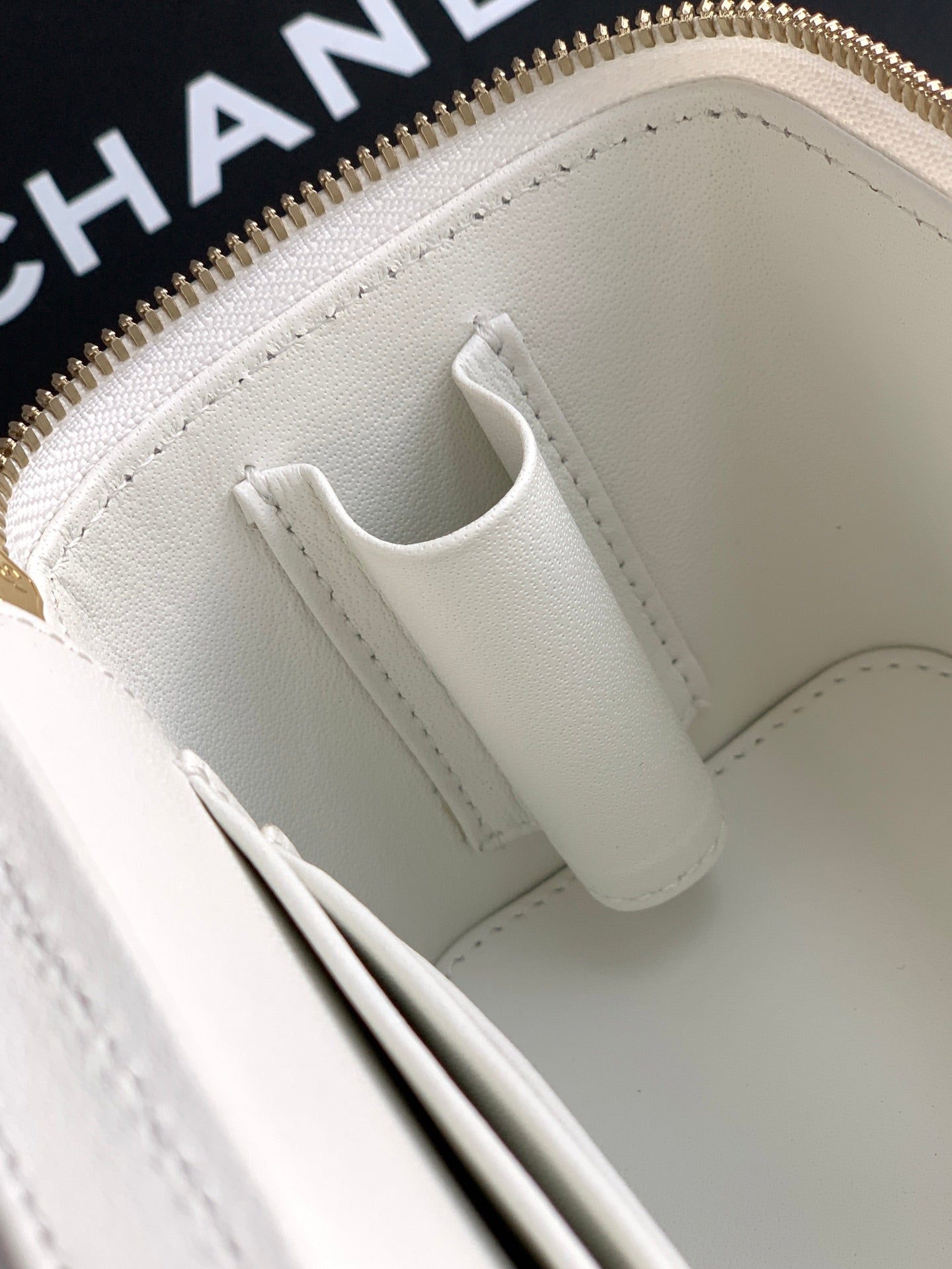 White leather bag interior with stitched top edge and slip pocket