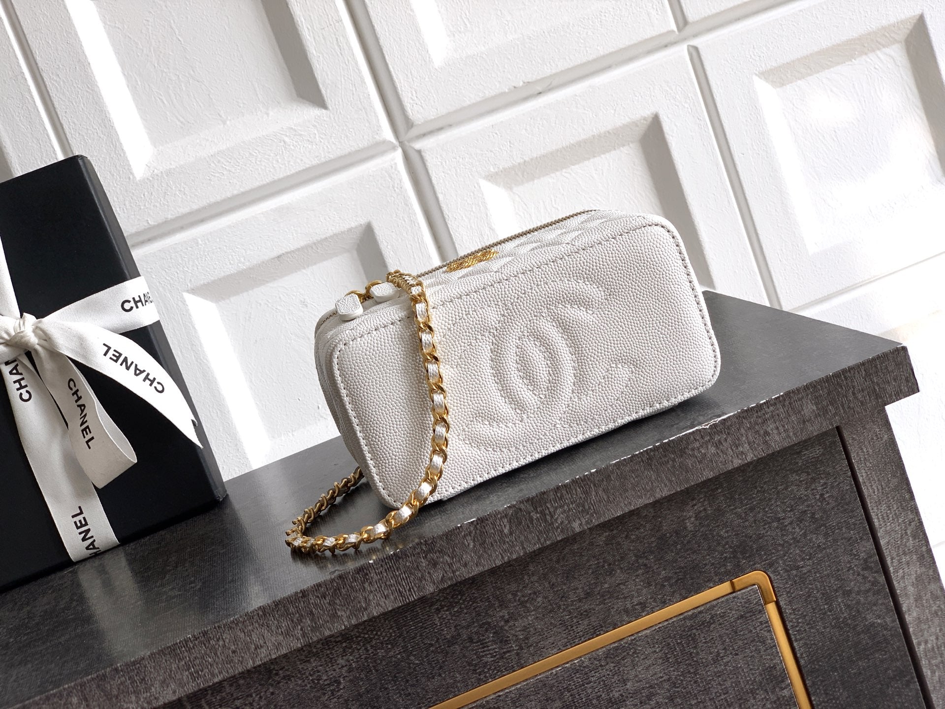Quilted white leather shoulder bag with gold chain strap and snap-front flap