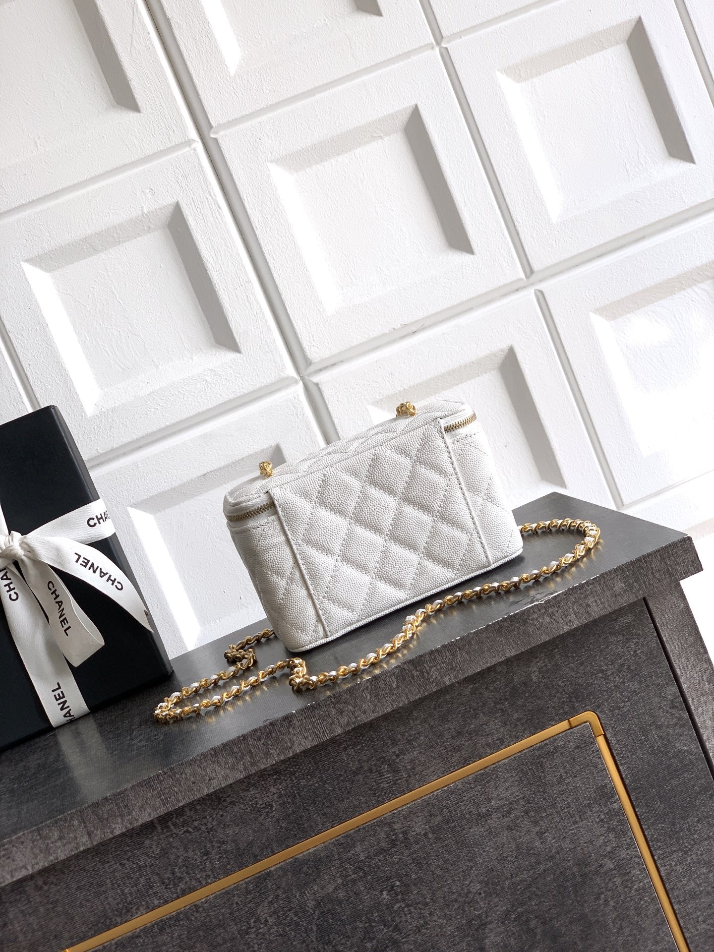 Quilted white leather bag with gold chain shoulder strap and front flap