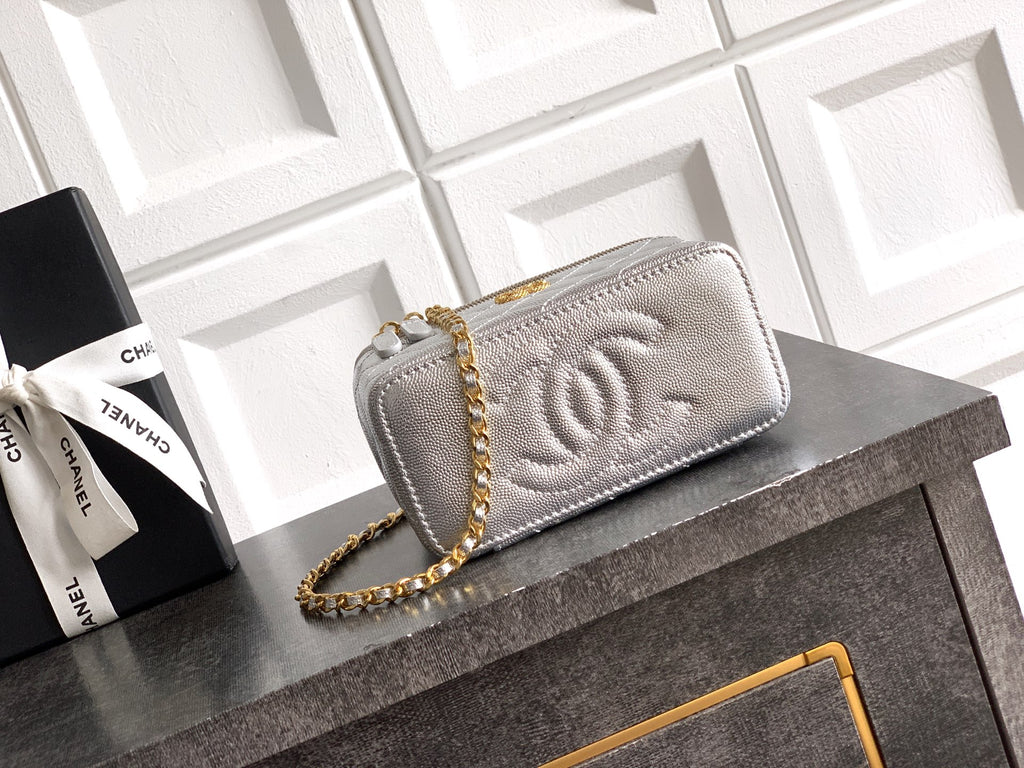 Light gray quilted Chanel bag with embossed CC logo on front flap.
