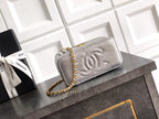 Light gray quilted Chanel bag with embossed CC logo on front flap.