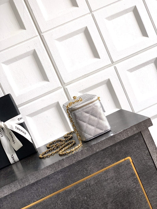 Light gray quilted Chanel bag with gold-tone chain strap and flap front.