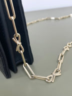 Dior chain strap with gold links attached to a quilted dark navy bag