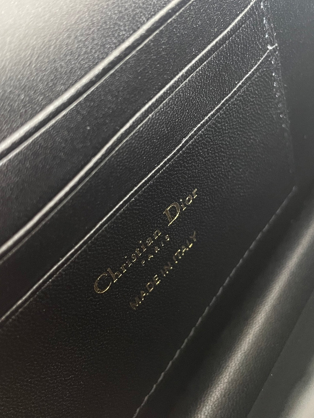 Dior embossed leather interior label on dark navy bag