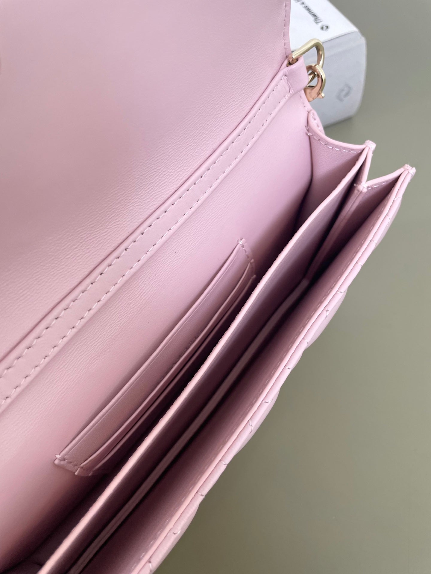 Pink leather flap bag interior pocket view with stitched edges