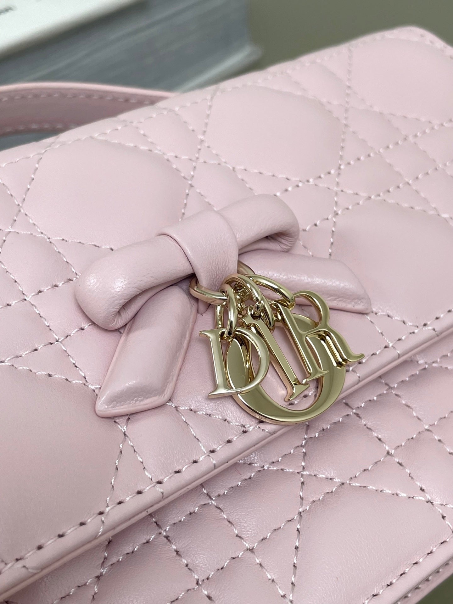 Dior pink quilted leather flap bag with bow emblem and gold-tone clasp