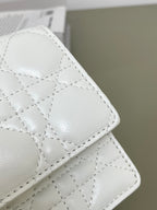 White quilted bag with stitched diamond pattern and rounded corner flap