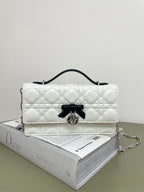 Dior quilted shoulder bag in white with black bow and silver hardware