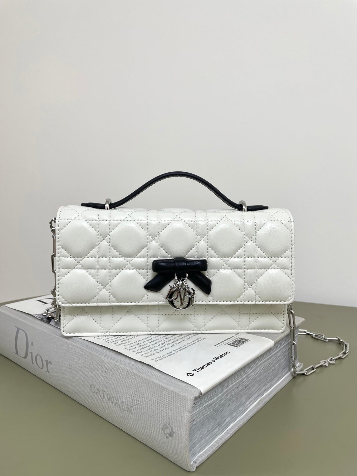 Dior quilted shoulder bag in white with black bow and silver hardware