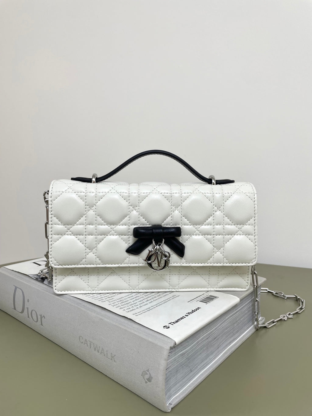 Dior quilted leather bag, white with black bow clasp and silver chain strap