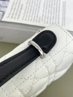 White quilted bag strap detail with black leather tab and silver buckle