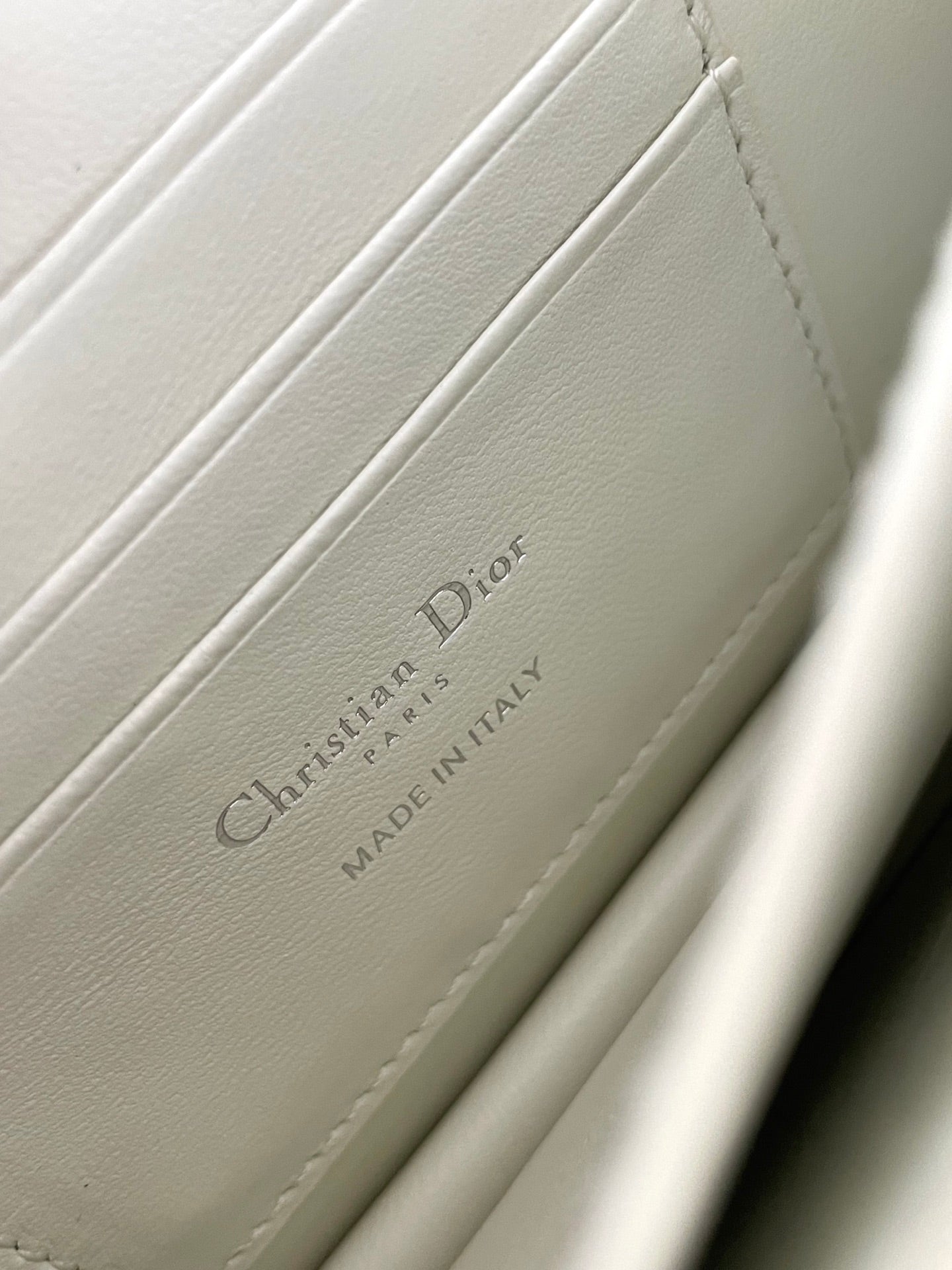 White leather bag with brand label text and 'Made in Italy' wording