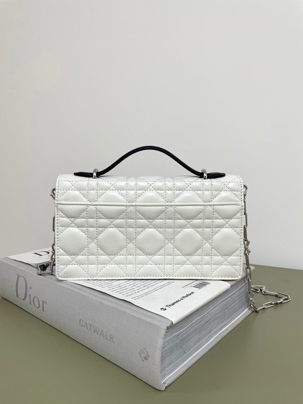 Dior small quilted white bag with black bow clasp and silver chain strap