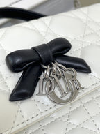 Dior charm hardware with black bow on white quilted leather bag