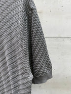 Amiri knit sweater side view in heather gray, textured herringbone knit.