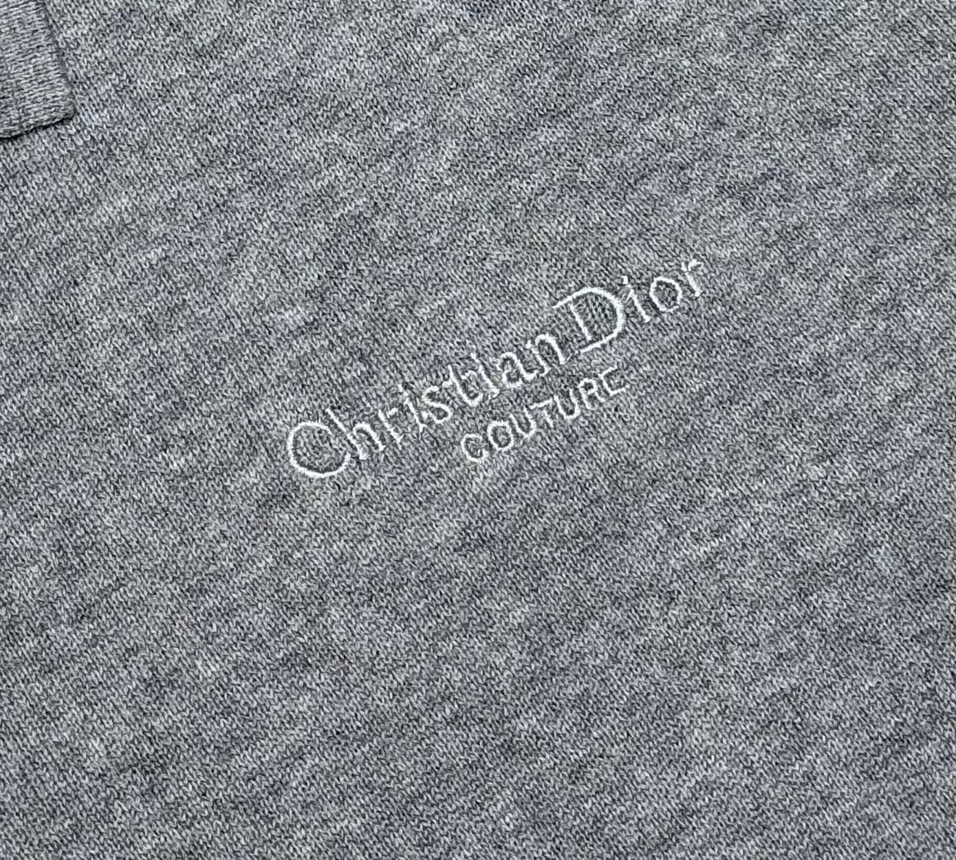 Prada polo shirt logo close-up: “Christian Dior Couture” text on heather gray knit